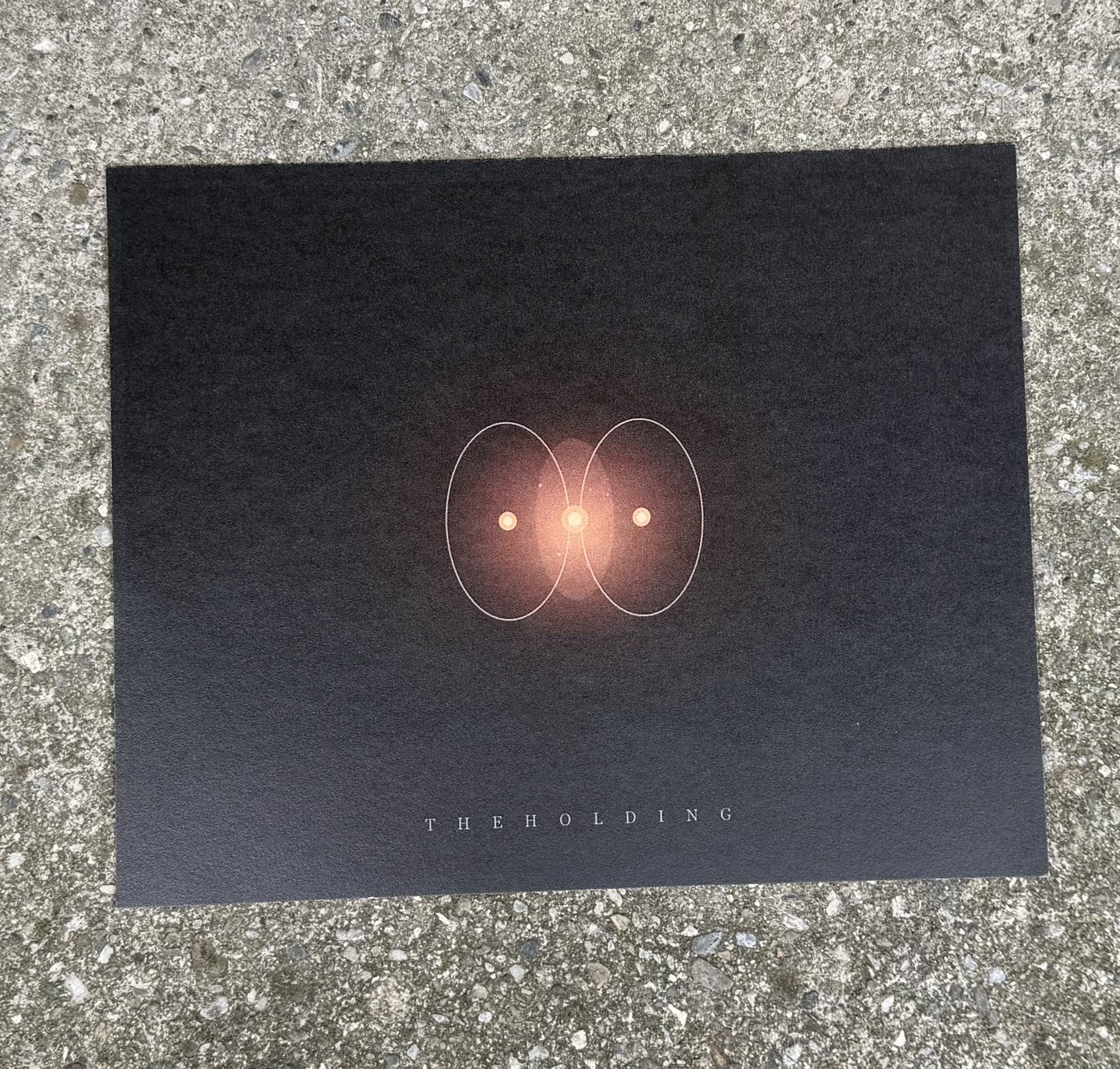 The Holding — two overlapping orbits with warm glow at their intersection
